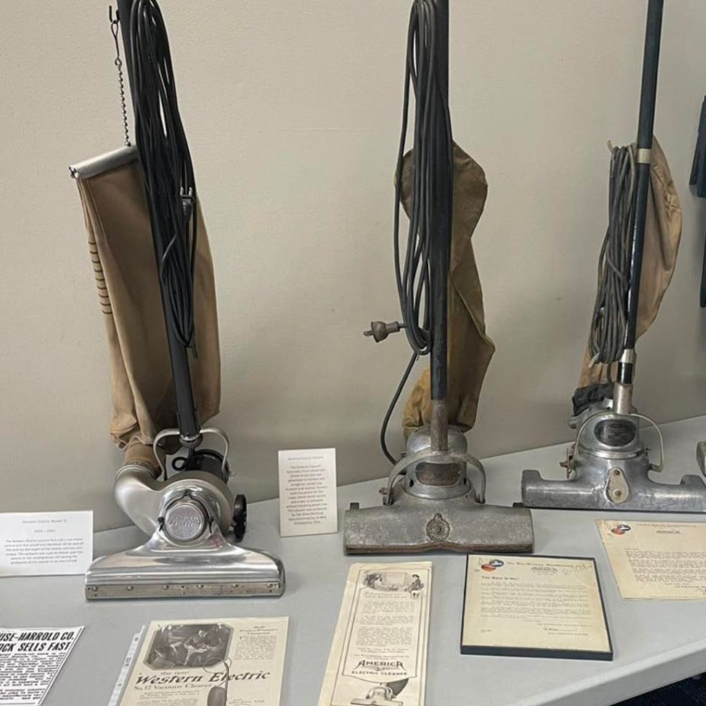 a group of vintage vacuum cleaners on a table
