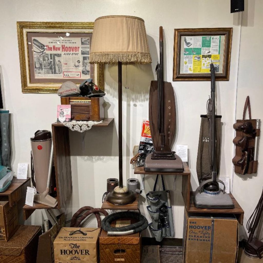 a room with a variety of 1940s vintage Hoover vacuum cleaners and other objects