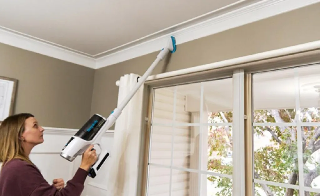 lady using the stick vacuum s67 to clean the ceilings