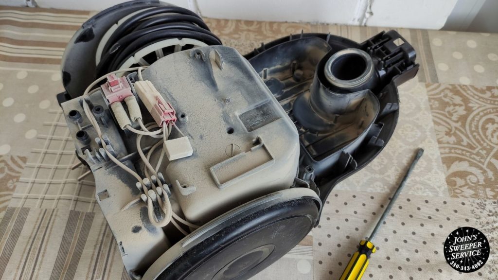 a broken vacuum cleaner sitting on top of a bed